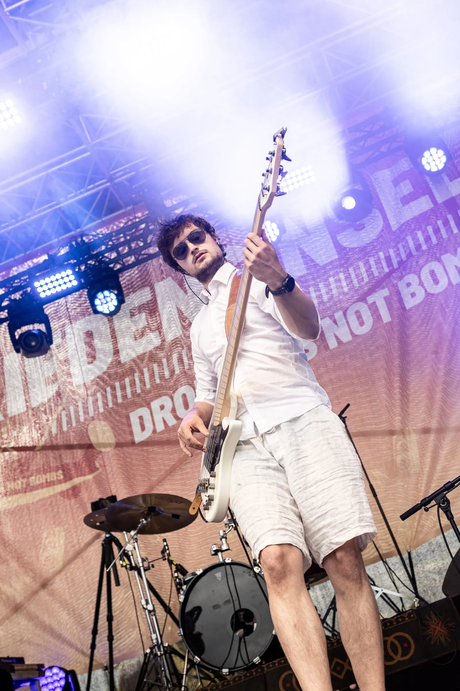 Bass mit Sonnenbrille vor der Friedensbühne-Wand