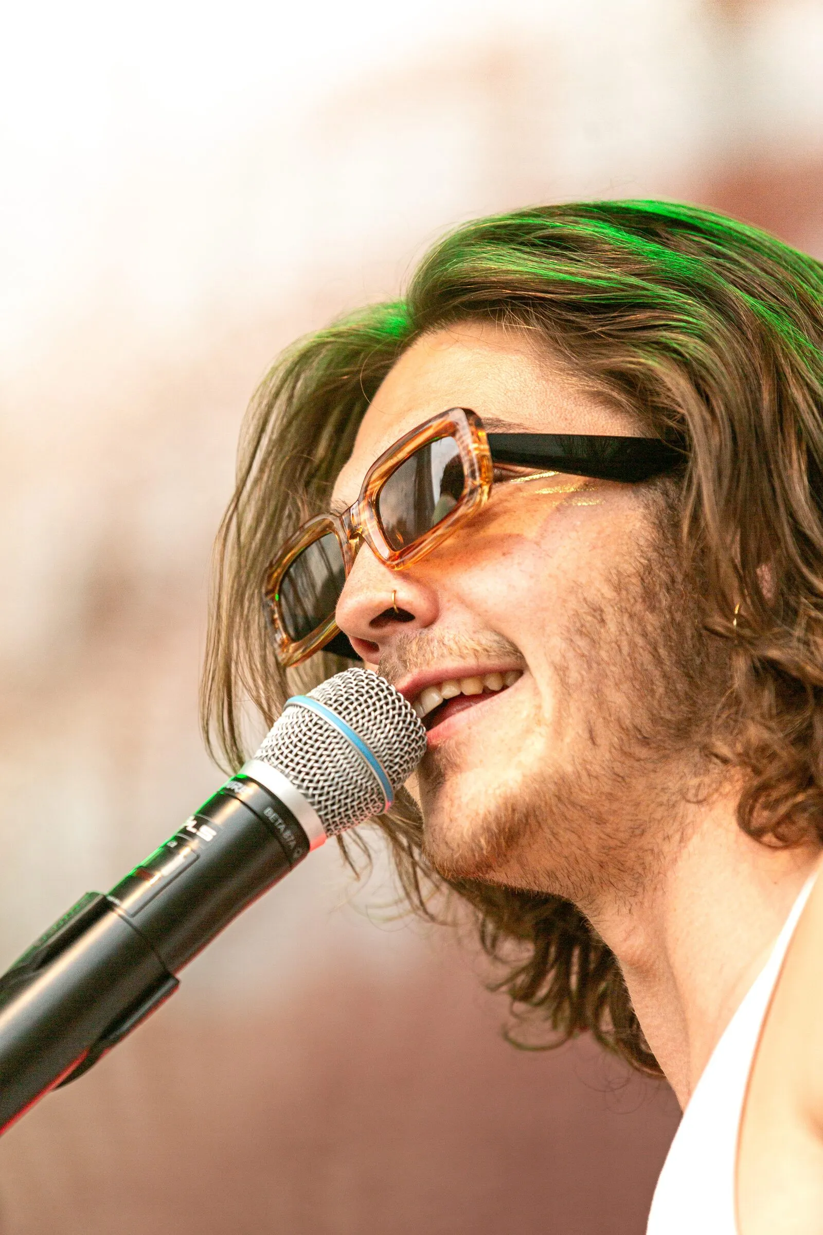 Gesang mit Sonnenbrille, lachend am Mikro