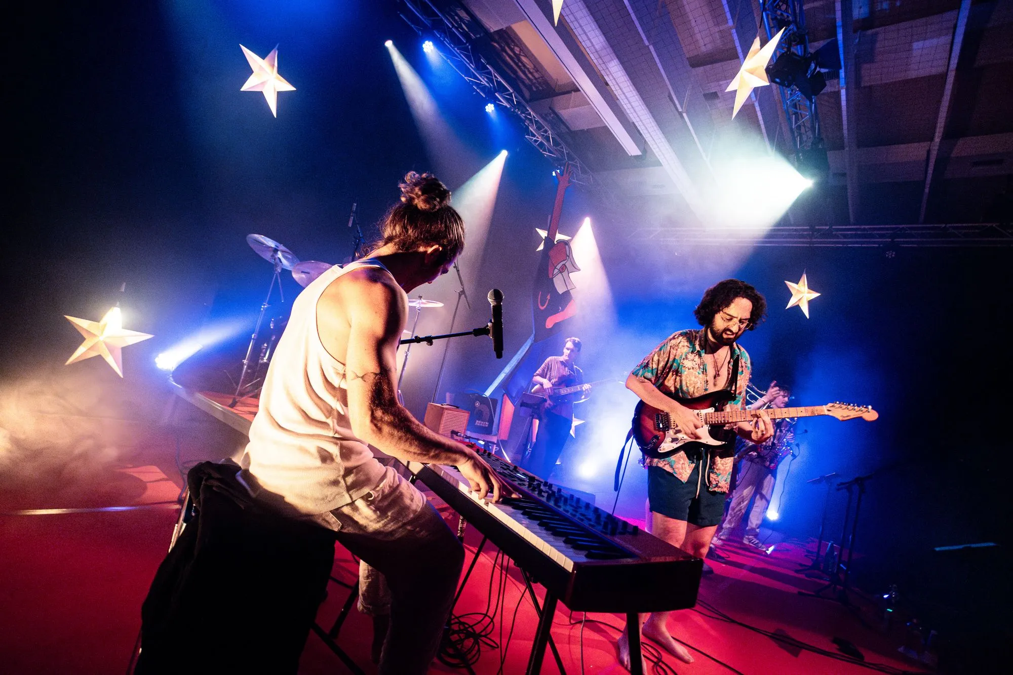 Keyboard und Gitarre unter Sternen und blauen Scheinwerfern