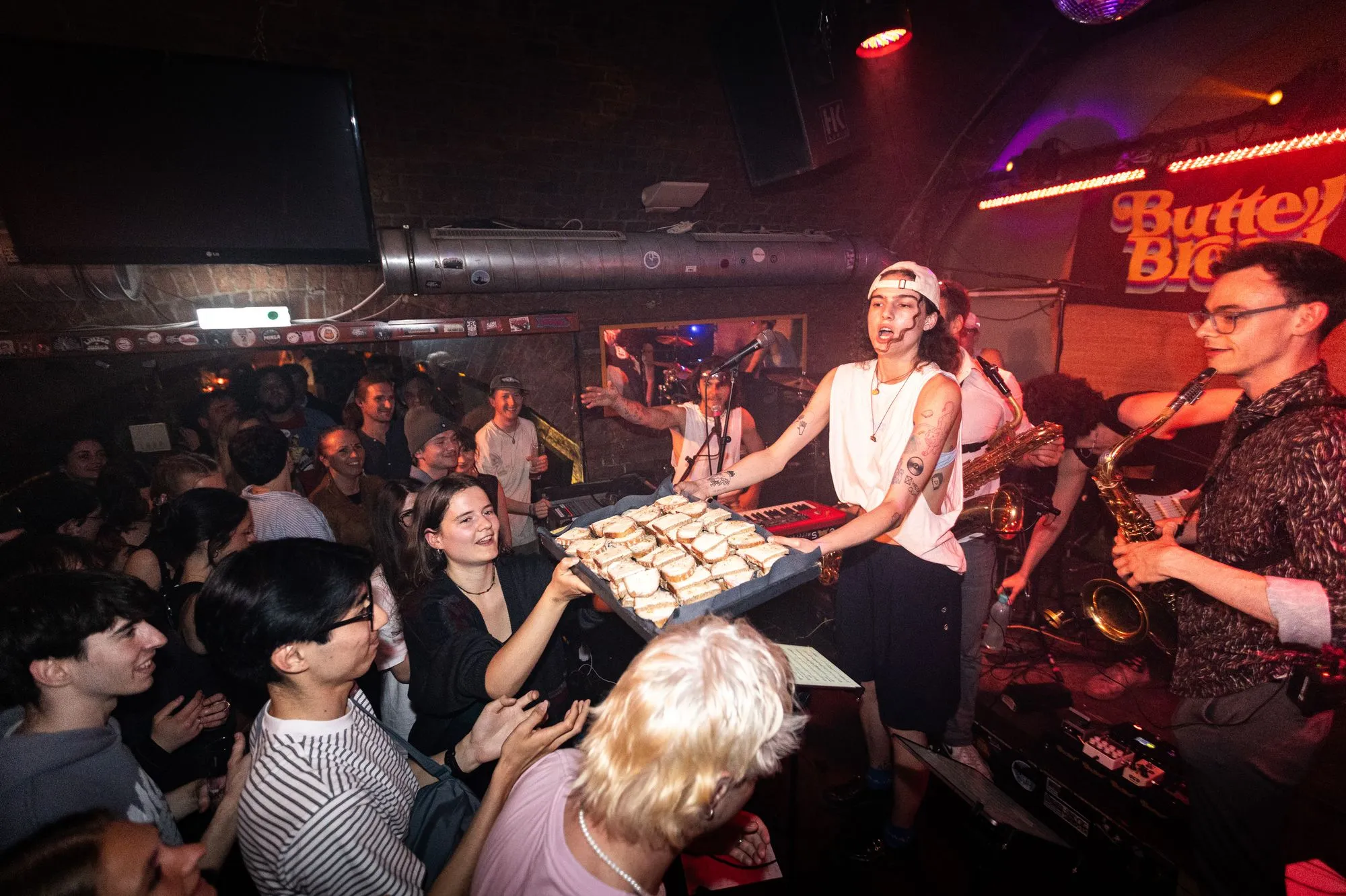 The singer handing a tray full of butter bread to the crowd