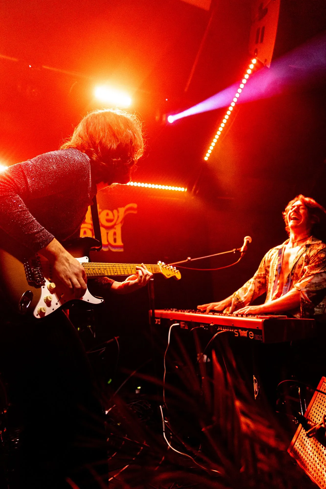 Gitarre und Keyboard unter roten Scheinwerfern