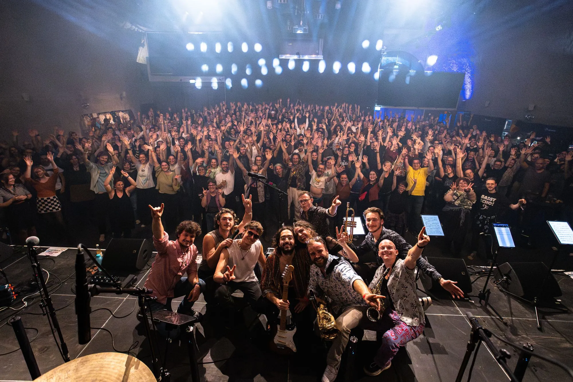 Group photo on stage in front of the cheering crowd