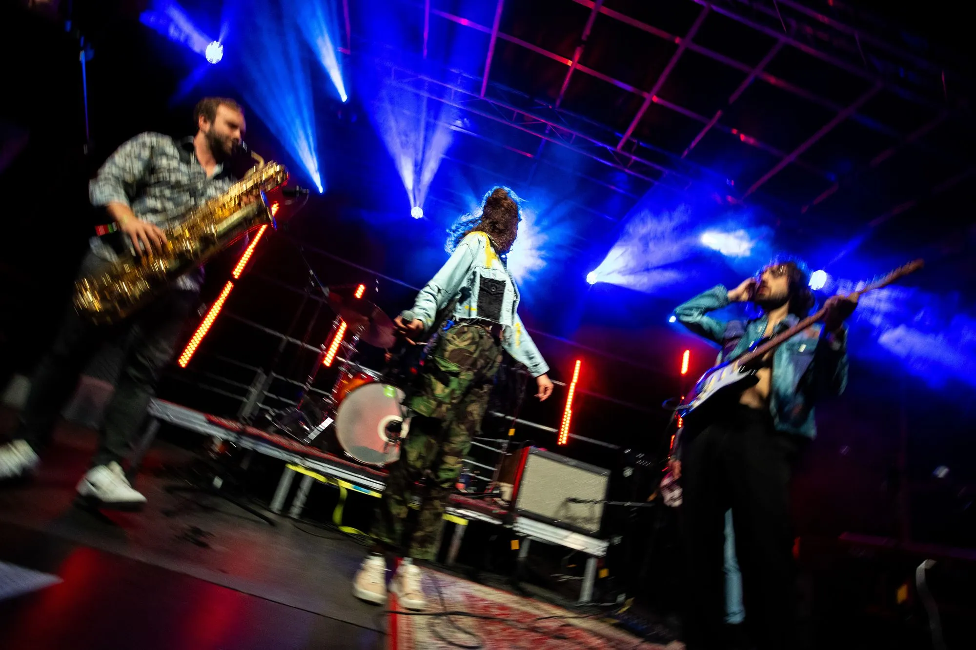 Saxofon, Gesang und Gitarre unter blauen Lichtern